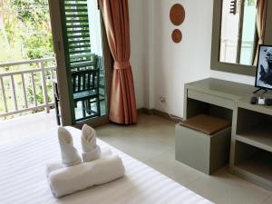 湄南海滩Ampha Place Hotel的客房设有一张白色椅子、一张书桌和一个阳台