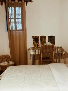 得土安Tarbi'aat Tetaoun 44, 17th century heritage的一间卧室配有一张床、两把椅子和一个窗户