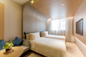 上海上海世博高科西路地铁站亚朵酒店的酒店客房,设有两张床和一张沙发