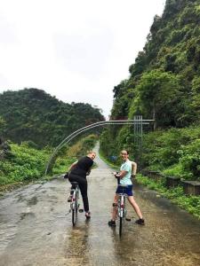 吉婆岛Cat Ba Gem Cruise的两个人骑着自行车在土路上