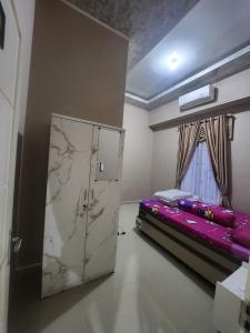 HalanganHomeStay Pandan Baru的一间设有床铺和冰箱的客房