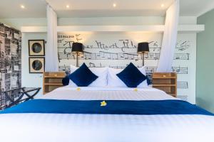 塞米亚克德鲁巴迪之四酒店的一间卧室配有一张带蓝白色枕头的大床