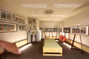 驹根市Suzuranso的墙上有很多图片的房间
