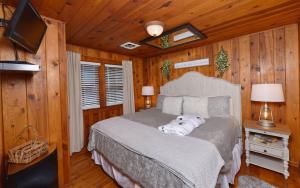 加特林堡River Romance的卧室配有一张床铺,位于带木墙的房间内
