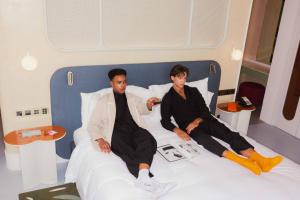 曼谷曼谷仕丹德大京都大厦酒店的坐在酒店房间床上的两个人