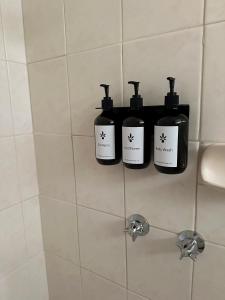 马拉库塔Motel Bream的浴室的架子上放了三瓶肥皂