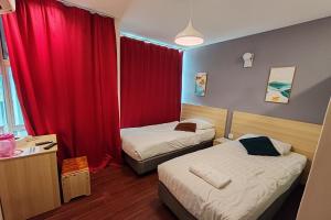 怡保Hotel 18的酒店客房设有两张床和红色窗帘