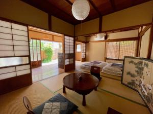 镰仓市古民家の宿 鎌倉楽庵的一间设有两张床和一张桌子的房间