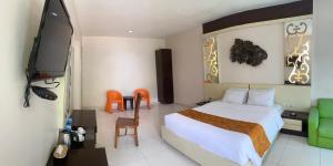 Kalibanteng-lorHotel New Puri Garden的一间酒店客房,配有一张床和一台电视