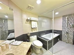 台中市美之旅商务饭店的一间带卫生间、浴缸和淋浴的浴室