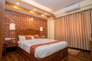 加德满都Madhuban Hotel的一间卧室设有砖墙和一张床