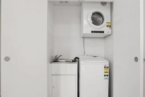 悉尼Stunning Apartment ATC10610的厨房里冰箱上面的微波炉