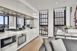 悉尼Stunning Apartment ATC10610的厨房配有白色橱柜和沙发