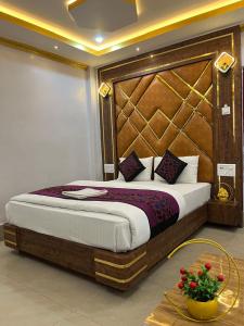 迪马普尔HOTEL COUNTRY INN的一间卧室配有一张大床和木制床头板