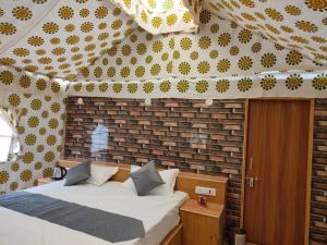 斋沙默尔Royal Adventure Camp & Resort的一间卧室设有一张床和砖墙