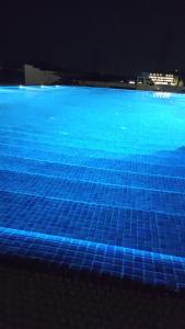 百乐费利克斯Hotel Abi - Baile Felix的蓝色泳池,地板上铺有蓝色瓷砖