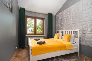 华沙Golden Villa Saska Kępa的一间卧室配有一张带黄色床单的床和一扇窗户。