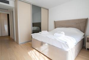 萨拉热窝Sarajevo Waves Aparthotel的卧室配有一张白色大床和镜子墙