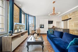 第戎La Suite Indivio - Appartement standing vue cathédrale的一间带蓝色沙发的客厅和一间厨房