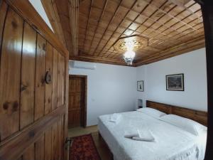 培拉特Guest House J.Prifti的一间卧室设有一张床和木制天花板