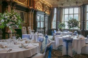 克鲁Crewe Hall Hotel & Spa - Cheshire的一间设有白色桌椅和鲜花的房间