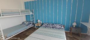 MésiVILLA KARA - Bed and Breakfast的一间卧室设有两张双层床,拥有蓝色的墙壁。