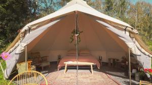 Nederweert-EindBell Tent in een Voedselbos的帐篷内提供一张床和椅子