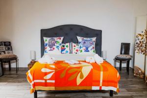 圣特罗佩la Romana Luxe et sérénité au cœur de Saint-Tropez Suites spacieuses avec jardin enchanteur的一间卧室配有一张带橙色毯子的床