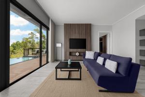 停泊岛Perhentian Marriott Resort & Spa的客厅配有蓝色的沙发和电视