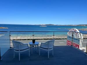 阿兰扎达Hotel La Lanzada的海景阳台上的桌椅