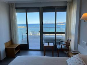 阿兰扎达Hotel La Lanzada的一间卧室配有一张床,享有海景