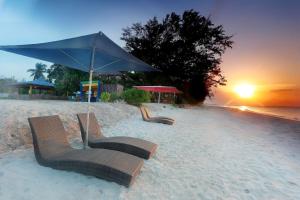 PasarbaruNew Belitung Holiday Resort的沙滩上两把椅子,放在遮阳伞下