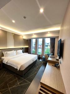 胡志明市Wah Fu Hotel的酒店客房,配有床和电视