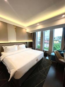 胡志明市Wah Fu Hotel的酒店客房设有一张大床和窗户。