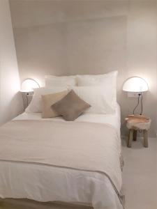 上阿兰Acogedor apartamento a pie de pistas cota 1500的配有白色枕头和两盏灯的白色床