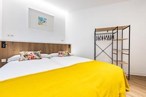 巴利亚多利德巴黎旅馆的一间卧室配有一张带黄色毯子的大床