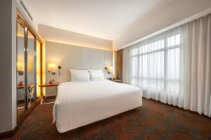 河内河内铂尔曼酒店的卧室设有白色的床和大窗户