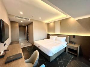 胡志明市Wah Fu Hotel的配有一张床和一张书桌的酒店客房
