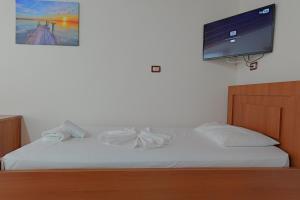 博尔什Vila Arturi的卧室配有一张壁挂式平面电视的床。