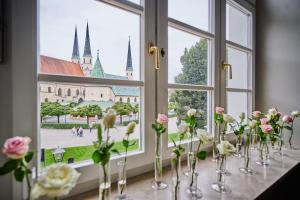 阿尔特廷Hotel Zur Post Altötting的花瓶装满桌子上的花的窗户