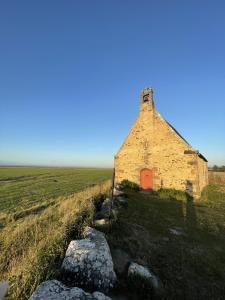 圣马洛Gîte à Saint-Marcan-Baie du Mont-Saint-Michel的田间中一座旧砖砌的建筑