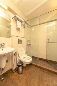 新德里Lutyens Bungalow的浴室配有卫生间、盥洗盆和淋浴。