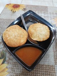 乌贾因Aarav Home Stay的两个饼干在黑色盘子里,有浸泡酱