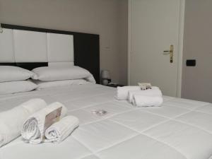 维罗纳斯罗斯酒店的一张白色大床,上面有毛巾