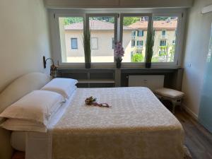 瓦伦纳Varenna Guest House的一间卧室设有一张床,窗户上装有鲜花