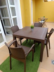 阿德耶Apartamentos ORLANDO en Costa Adeje的绿色地毯上的木桌和椅子