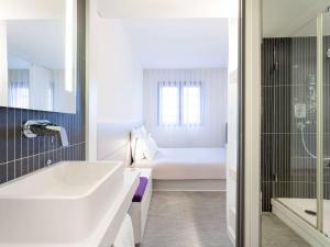 佩皮尼昂Novotel Suites Perpignan Centre的一间带水槽和浴缸的浴室以及一张床