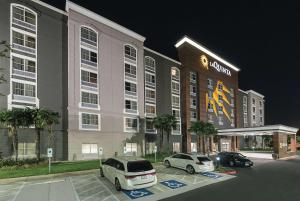 圣安东尼奥La Quinta Inn & Suites by Wyndham San Antonio Downtown的两辆车停在停车场的酒店