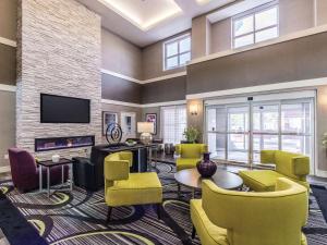 圣安东尼奥La Quinta Inn & Suites by Wyndham San Antonio Downtown的客厅配有黄色椅子和电视