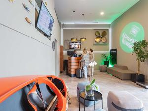 里斯本Ibis Styles Lisboa Centro Liberdade NE的两人站在客厅